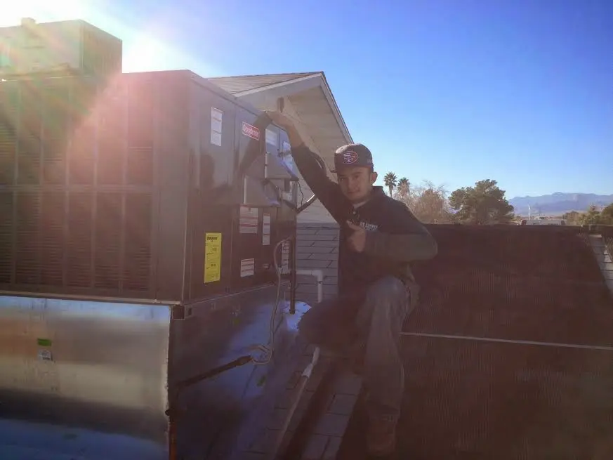 HVAC technician performing Air Duct Repair on a rooftop unit in Smithfield